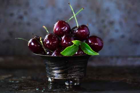 red cherries on stainless steel bowl